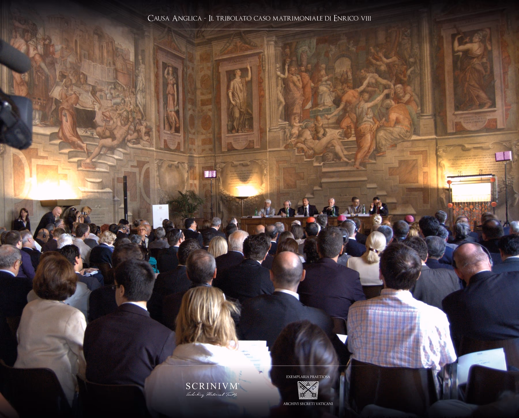The Sala dei Cento Giorni packed with people during the presentation, frescoes on the walls and the speakers table at the far end.