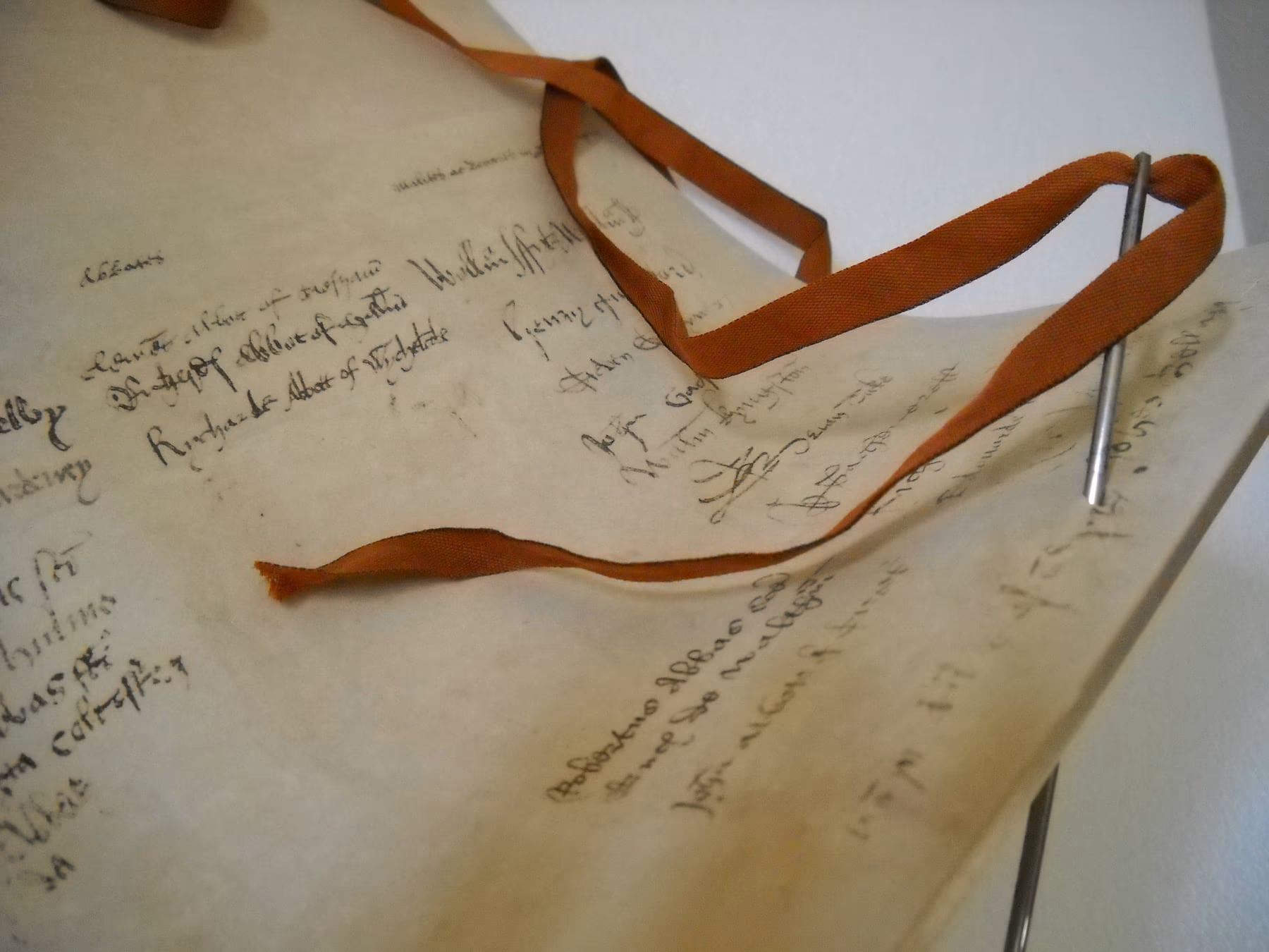 Close-up of the Causa Anglica parchment during preparation, with the silk ribbon and handwritten notes on the support.