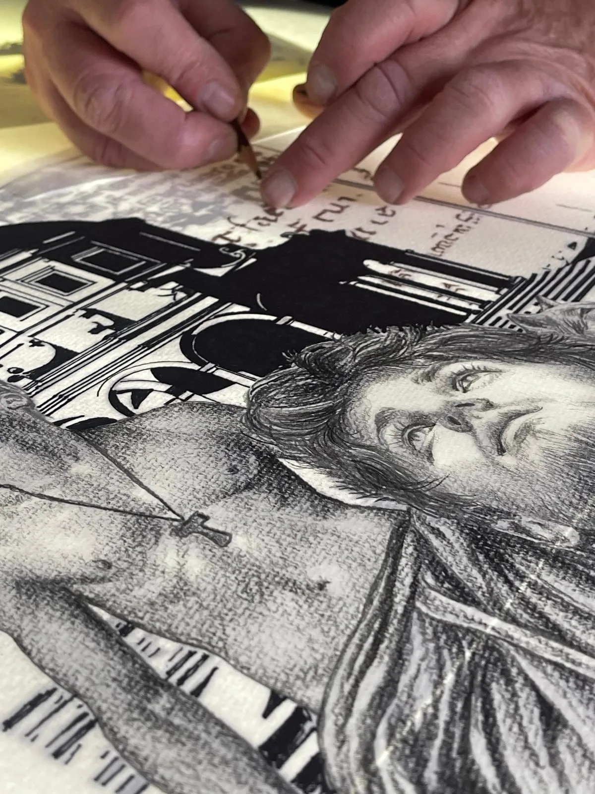 The hands of Giorgio Lupattelli at work on a pencil drawing, where a face and an architecture can be made out.