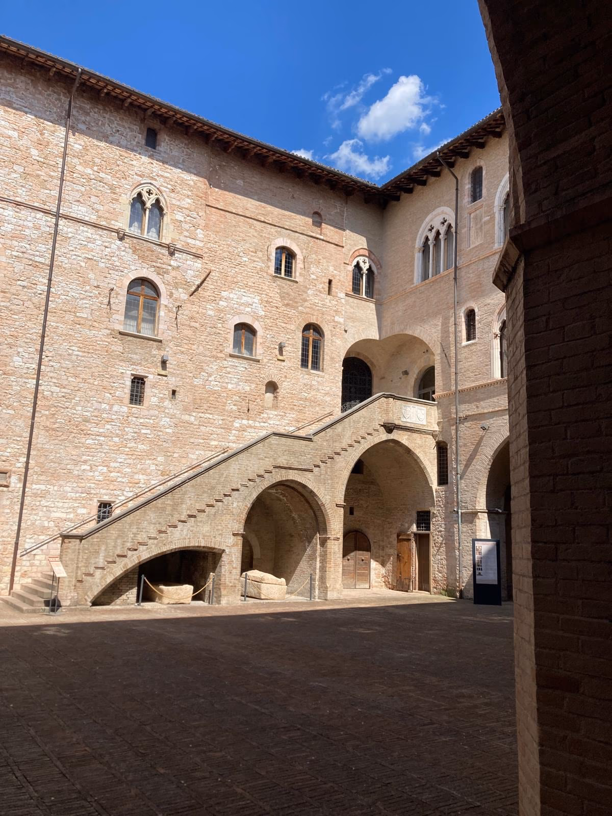 The courtyard of Palazzo Trinci in Foligno, with its stone staircase and arcades.
