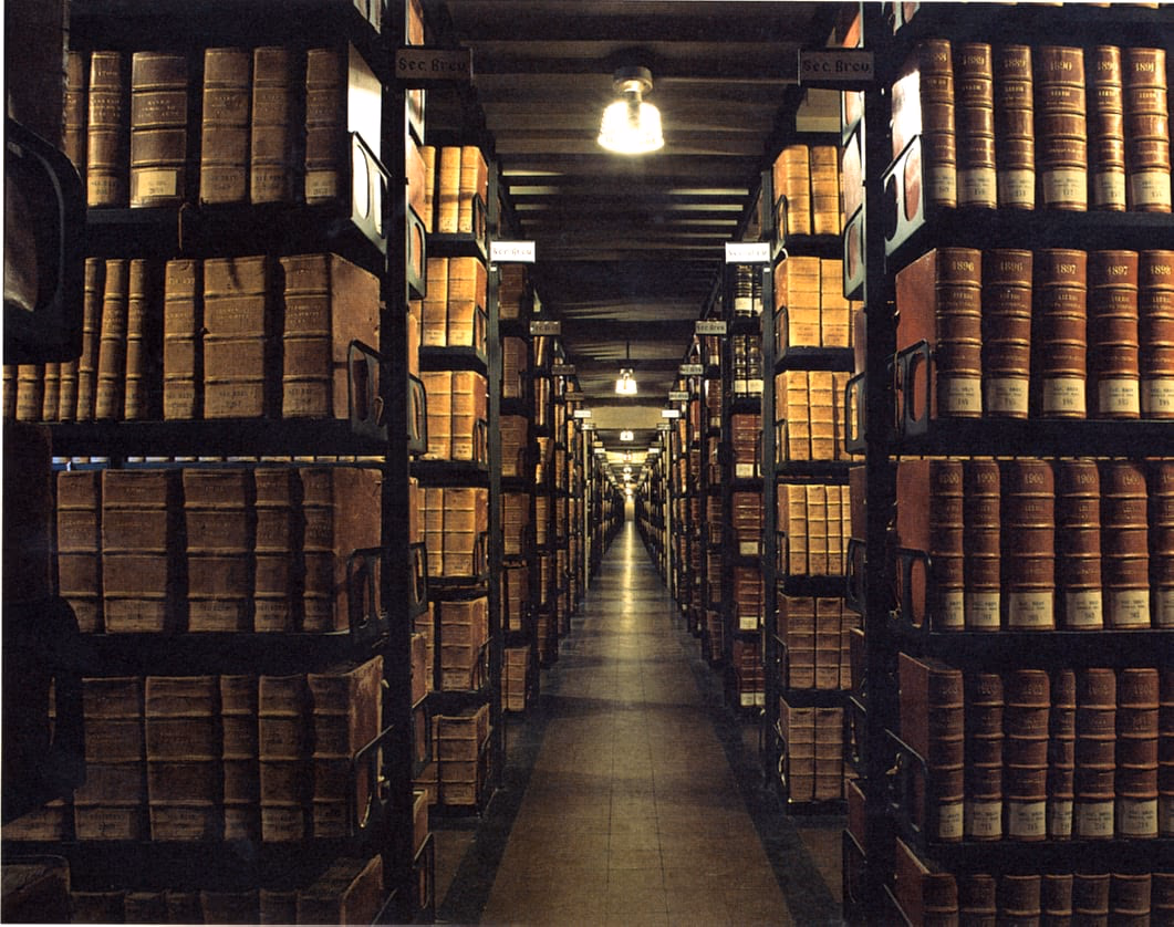 A corridor of the Vatican Apostolic Archive, its shelves receding into the distance.