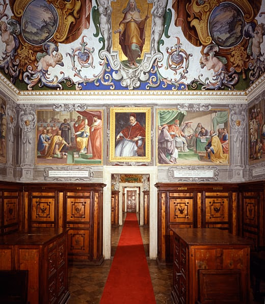 One of the Pauline rooms of the Vatican Apostolic Archive, frescoed, with wooden cabinets and a red carpet.